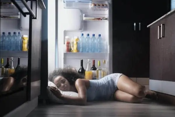 girl sleeping in front of fridge