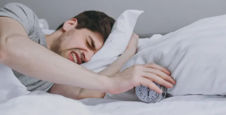 man sleeping turn off alarm clock